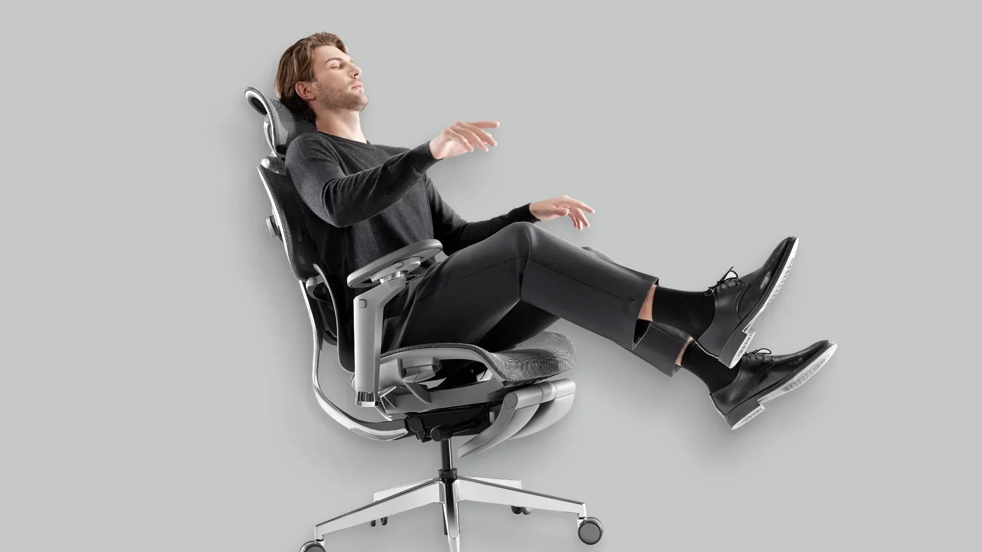 Man reclining in a Hinomi X1 ergonomic chair, demonstrating its full recline and leg rest extension for maximum comfort and relaxation.